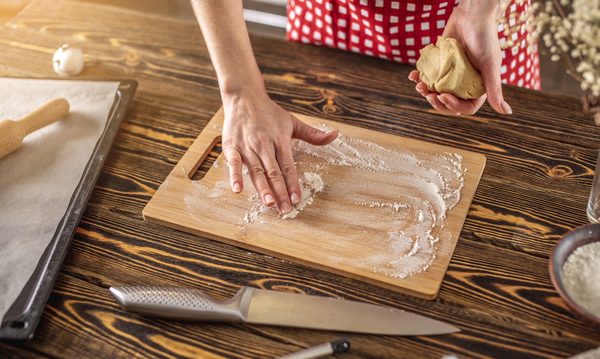 hands preparing dough on wooden board